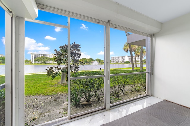 unfurnished sunroom featuring a water view