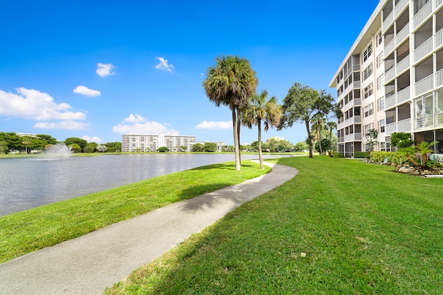 view of property's community with a yard and a water view