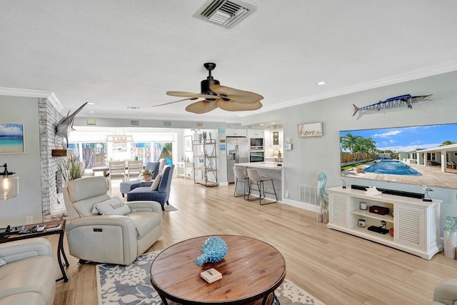 living room with light hardwood / wood-style floors, ceiling fan, and crown molding