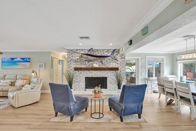 living room with a brick fireplace, ornamental molding, a healthy amount of sunlight, and light hardwood / wood-style floors