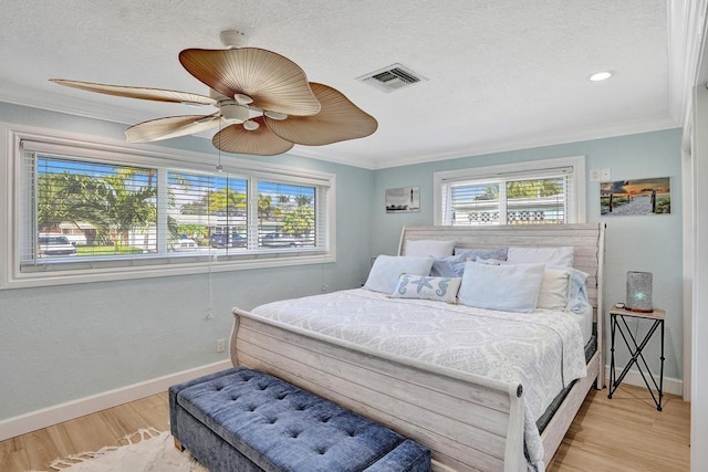 bedroom with ceiling fan, crown molding, a textured ceiling, and light wood-type flooring