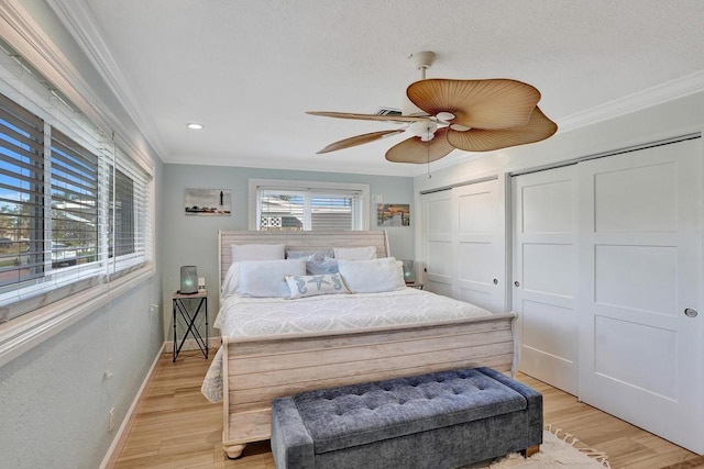 bedroom with ceiling fan, crown molding, and light hardwood / wood-style floors