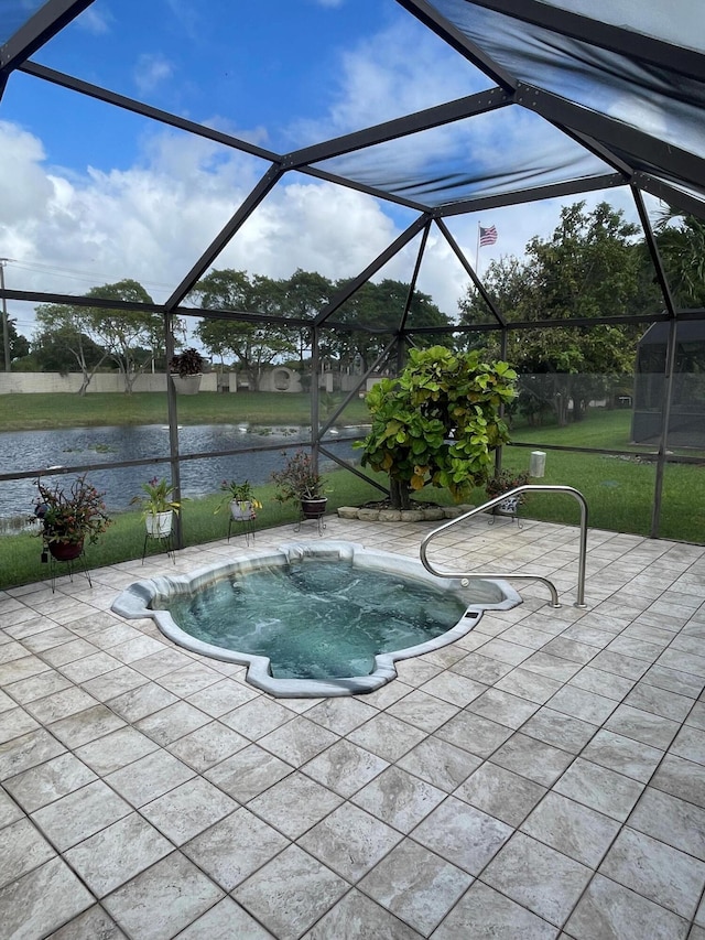 view of pool with glass enclosure, a water view, a yard, and a patio