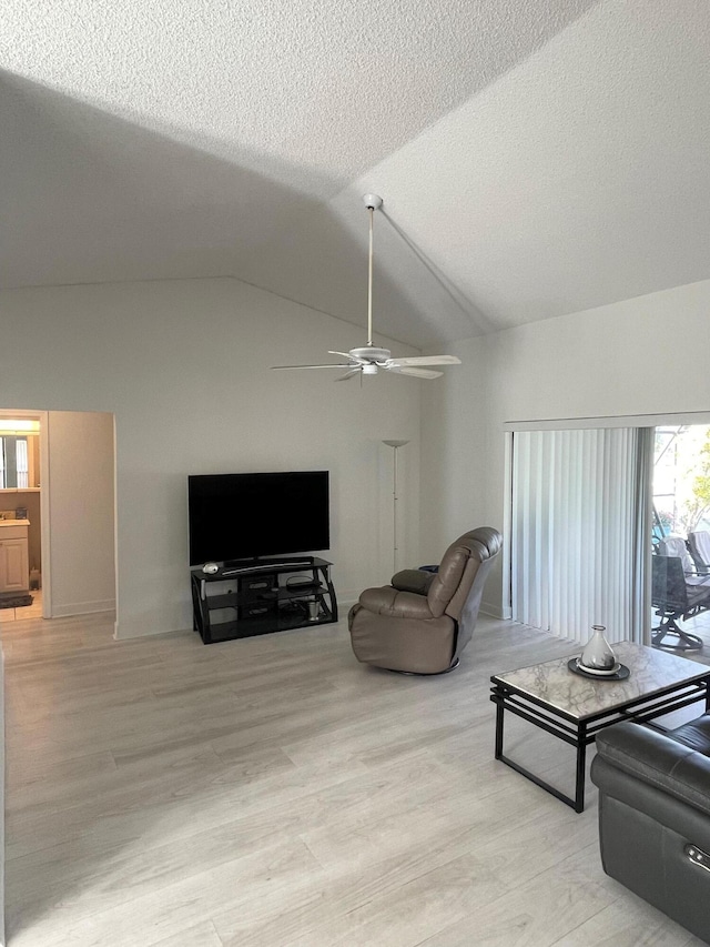 living room with ceiling fan, light hardwood / wood-style floors, lofted ceiling, and a textured ceiling