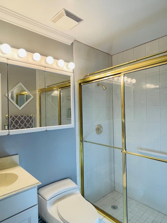 bathroom featuring vanity, toilet, an enclosed shower, and ornamental molding