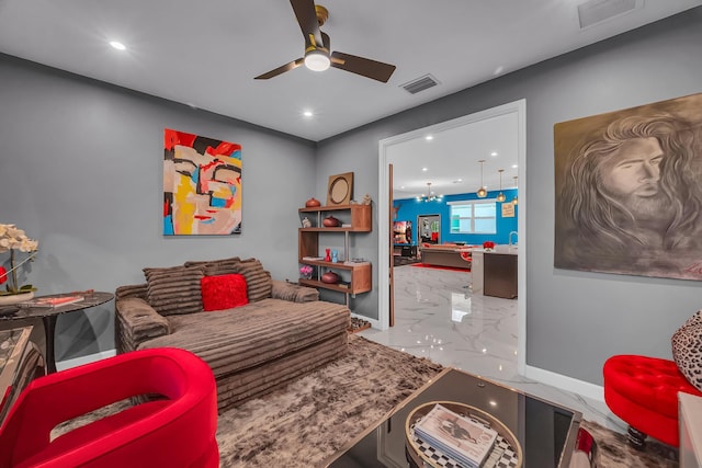 living room with ceiling fan with notable chandelier