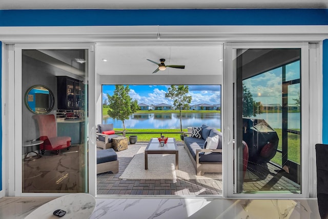 doorway to outside with a water view, a healthy amount of sunlight, and ceiling fan