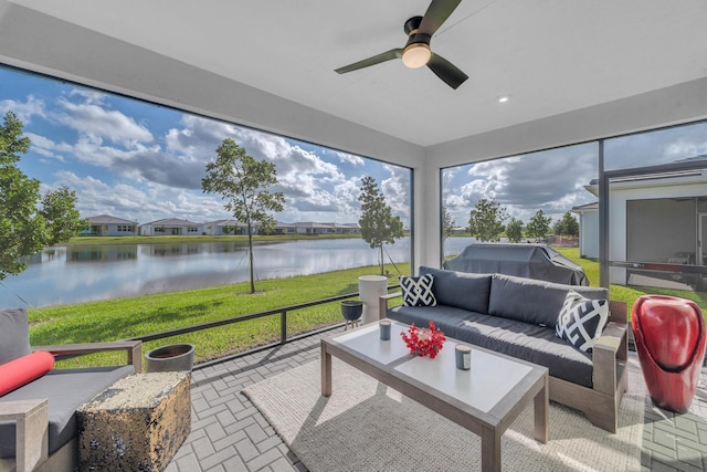 sunroom / solarium with a water view and ceiling fan