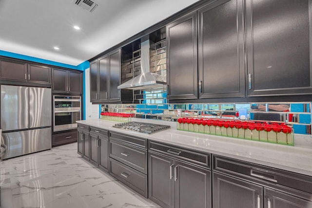 kitchen with decorative backsplash, wall chimney range hood, and stainless steel appliances