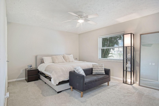 bedroom featuring ceiling fan, a textured ceiling, and light carpet