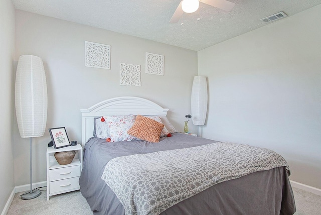 carpeted bedroom featuring a textured ceiling and ceiling fan