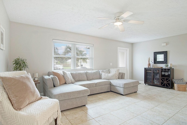 living room featuring ceiling fan, a textured ceiling, and light tile patterned floors