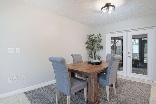 tiled dining area featuring french doors and a textured ceiling