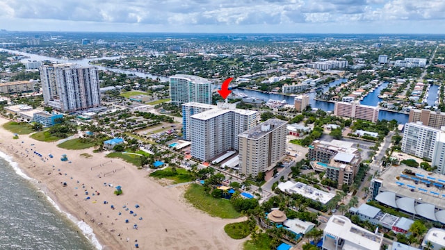 drone / aerial view featuring a water view and a beach view