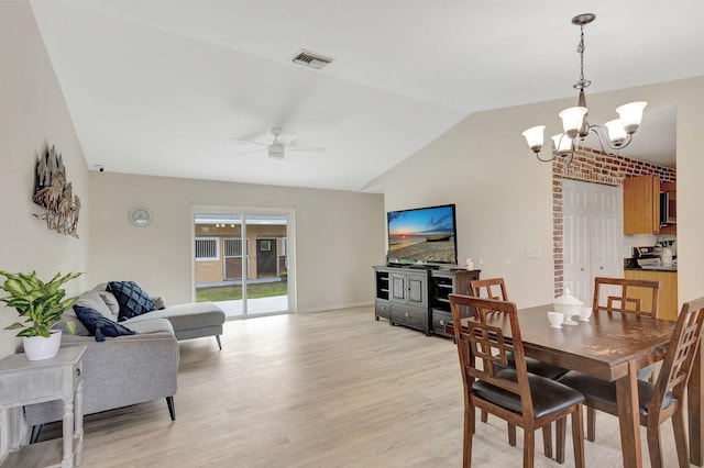 dining room featuring light hardwood / wood-style floors, lofted ceiling, and ceiling fan with notable chandelier