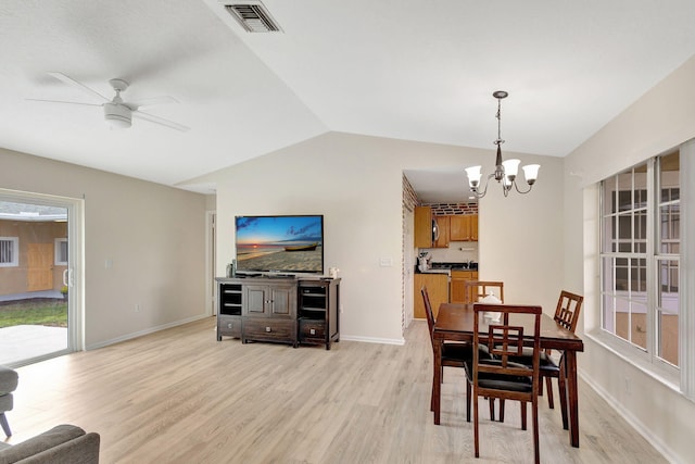 dining space with vaulted ceiling, light hardwood / wood-style flooring, and ceiling fan with notable chandelier