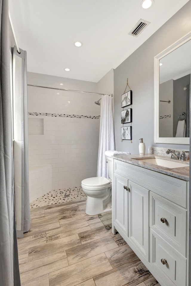 bathroom with vanity, curtained shower, toilet, and hardwood / wood-style flooring