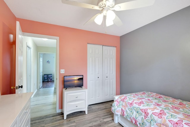 bedroom with light hardwood / wood-style floors, a closet, and ceiling fan