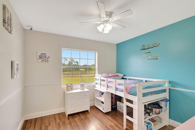 bedroom with ceiling fan, hardwood / wood-style flooring, and a textured ceiling