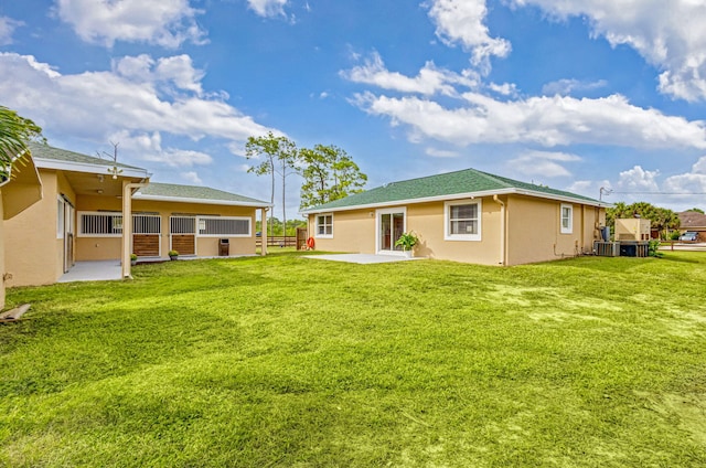 rear view of property featuring central air condition unit, a patio area, and a yard