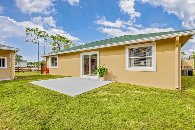 rear view of property featuring a yard, a patio, and central AC unit