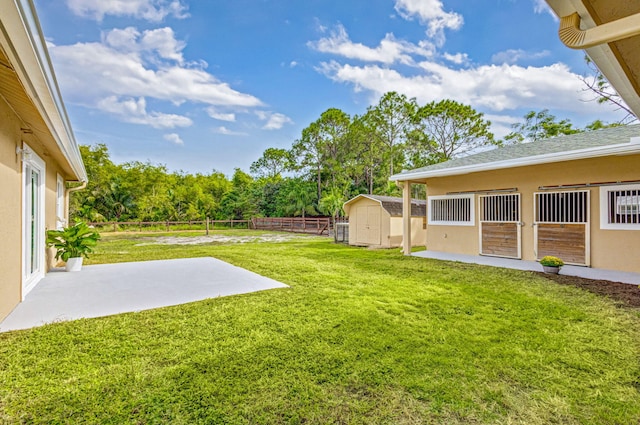 view of yard with a storage unit and a patio area