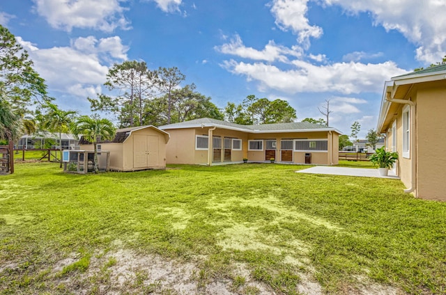 back of house featuring a patio, a storage unit, and a lawn