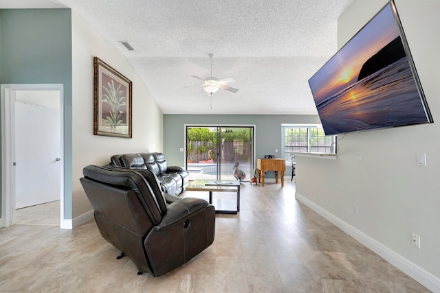 living room featuring ceiling fan and a textured ceiling