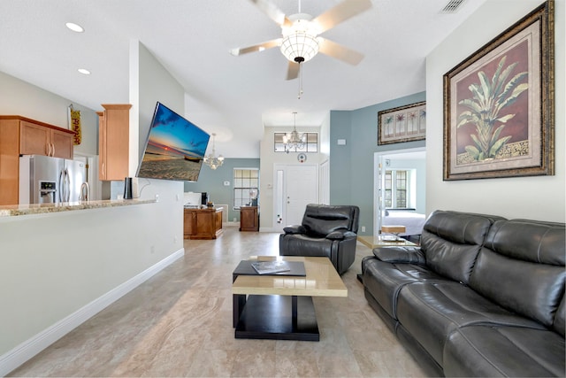 living room with sink and ceiling fan with notable chandelier