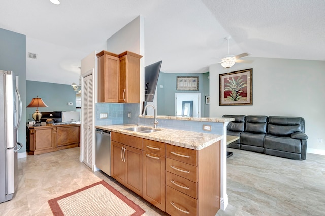 kitchen featuring kitchen peninsula, ceiling fan, appliances with stainless steel finishes, vaulted ceiling, and sink