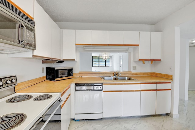 kitchen with sink, dishwasher, electric range oven, white cabinetry, and light tile patterned floors