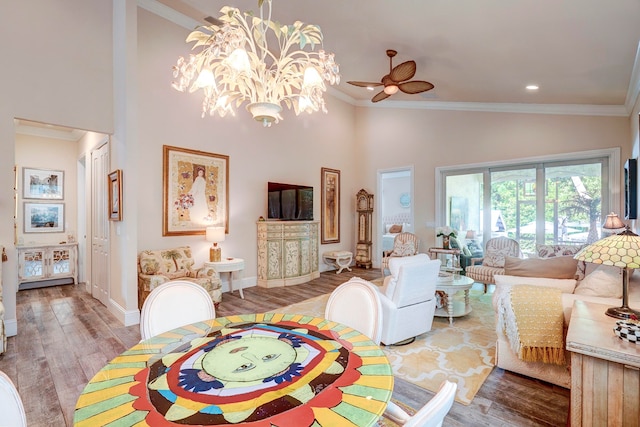 living room featuring light hardwood / wood-style floors, ornamental molding, high vaulted ceiling, and ceiling fan with notable chandelier