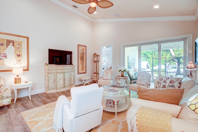 living room featuring light hardwood / wood-style flooring, ornamental molding, high vaulted ceiling, and ceiling fan