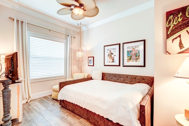 bedroom with crown molding, light hardwood / wood-style floors, and ceiling fan