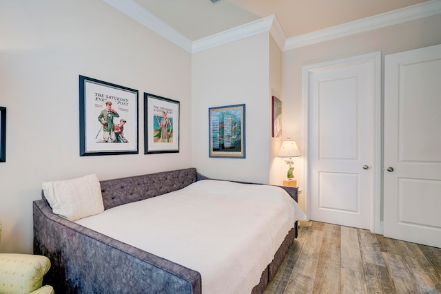 bedroom with ornamental molding and hardwood / wood-style floors