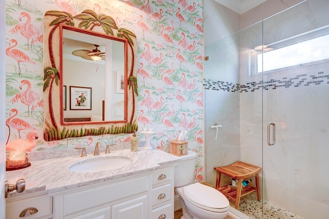 bathroom featuring vanity, a shower with shower door, toilet, and ceiling fan