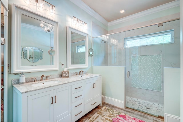 bathroom featuring a shower with door, hardwood / wood-style flooring, ornamental molding, and vanity