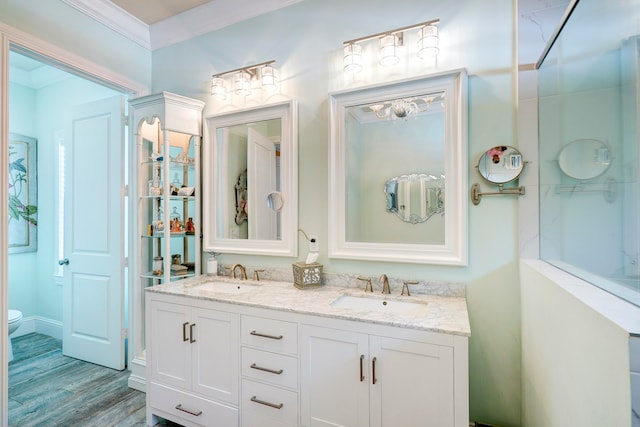 bathroom with vanity, ornamental molding, toilet, and wood-type flooring