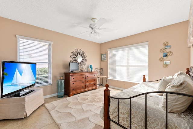 tiled bedroom with a textured ceiling and ceiling fan