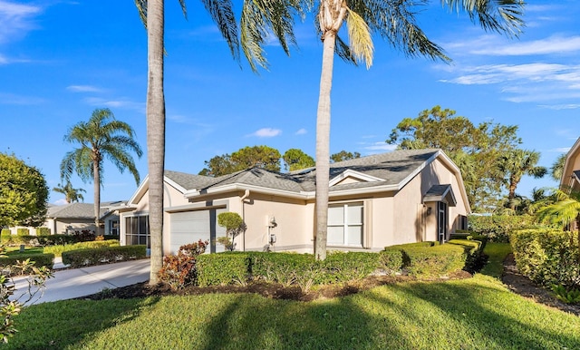 single story home featuring a front yard and a garage