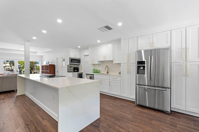 kitchen featuring light stone counters, stainless steel appliances, dark hardwood / wood-style flooring, sink, and white cabinets