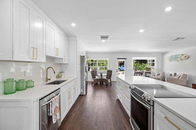 kitchen featuring dark hardwood / wood-style flooring, white cabinetry, sink, and appliances with stainless steel finishes