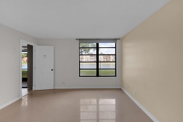 spare room with light tile patterned flooring and a healthy amount of sunlight