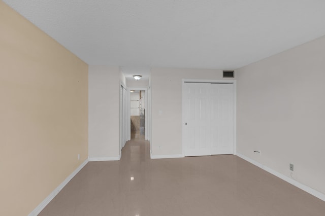 unfurnished room with a textured ceiling