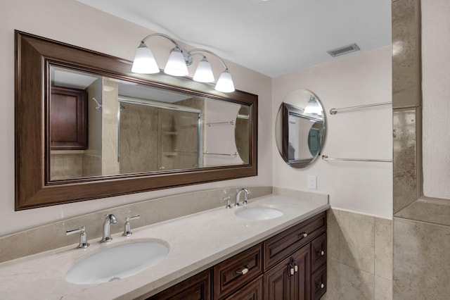 bathroom featuring a shower with door, vanity, and tile walls