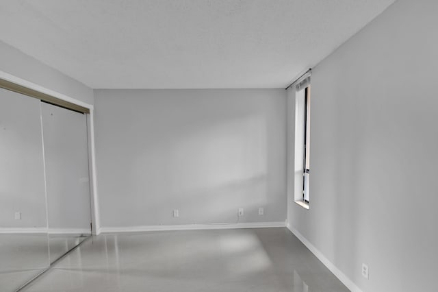 unfurnished bedroom featuring multiple windows and a textured ceiling