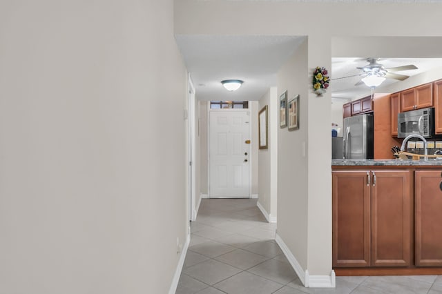 hallway with light tile patterned floors and a textured ceiling