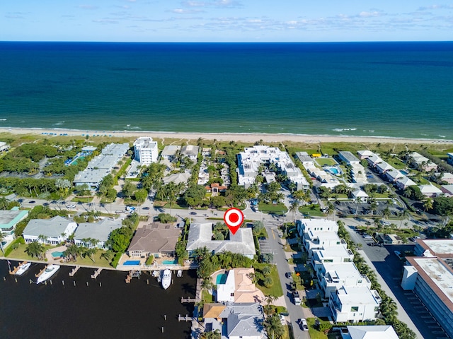 birds eye view of property with a water view and a beach view