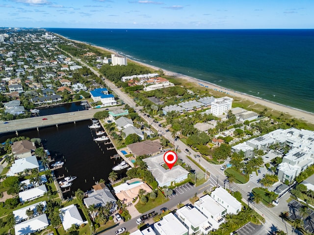 birds eye view of property with a water view and a beach view