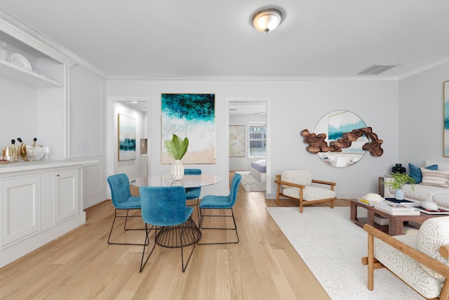 dining area featuring ornamental molding and light wood-type flooring